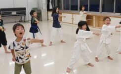 一生懸命に空手の正拳突きを練習する保育園・小学生の子供たち