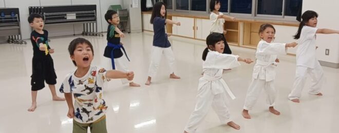 一生懸命に空手の正拳突きを練習する保育園・小学生の子供たち