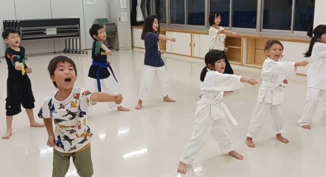 一生懸命に空手の正拳突きを練習する保育園・小学生の子供たち