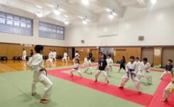 一般大人と少年たちのグループに分かれて空手動作の練習をしているようす