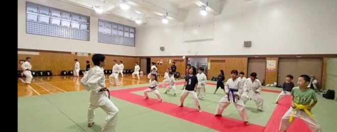 一般大人と少年たちのグループに分かれて空手動作の練習をしているようす