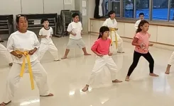 四股立ちという空手の基本の立ち方を練習中の小学生たち