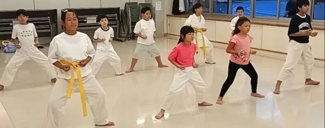 四股立ちという空手の基本の立ち方を練習中の小学生たち