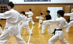 道場で大人と子供の道場生たちが並んで一緒に空手の型を稽古する様子|横浜関内の金井空手道場