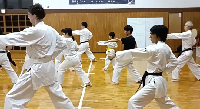 道場で大人と子供の道場生たちが並んで一緒に空手の型を稽古する様子|横浜関内の金井空手道場